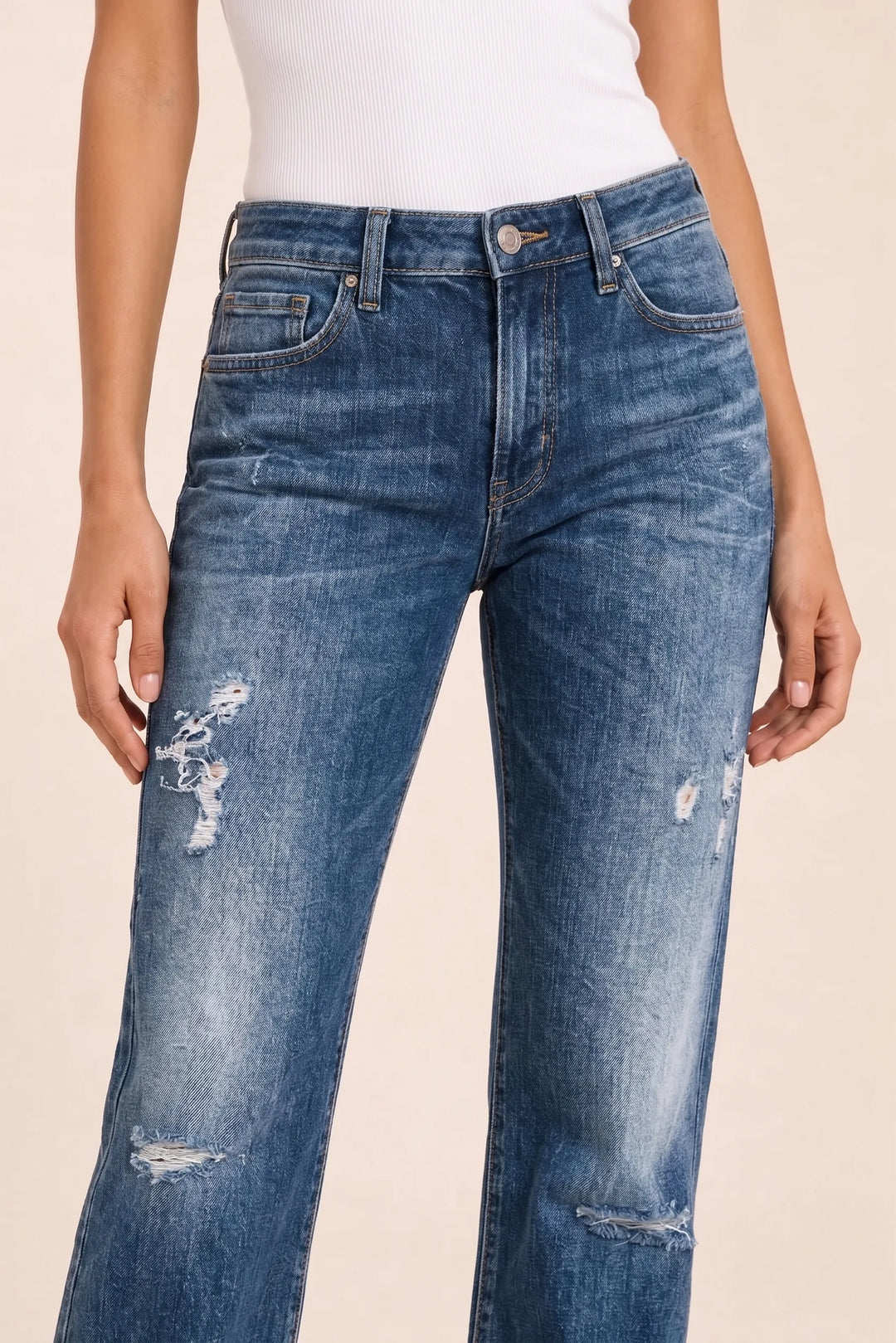 Close-up detail of distressed fabric texture on dark blue wide-leg jeans