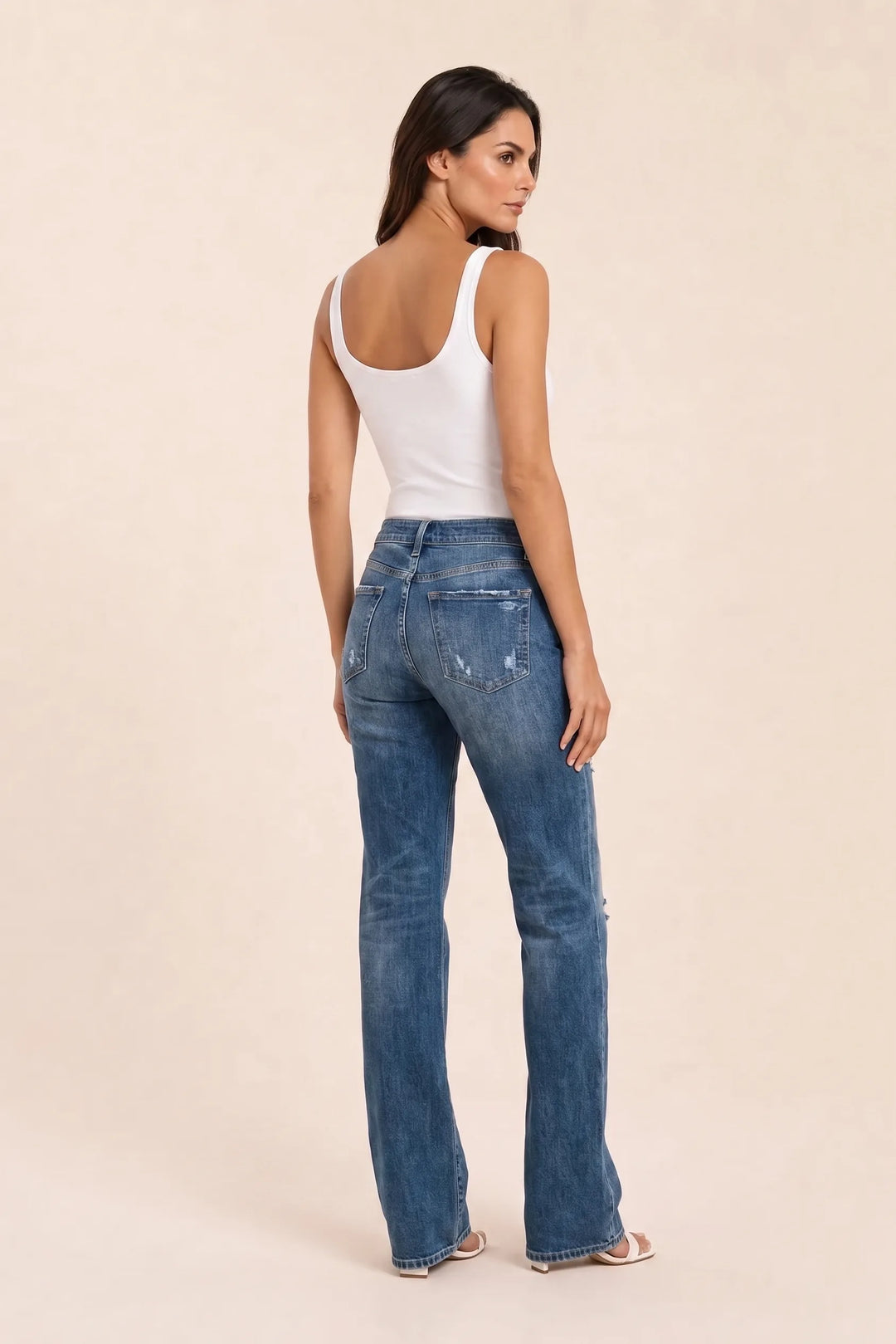 Dark blue distressed wide-leg jeans on a model in a three-quarter turn pose