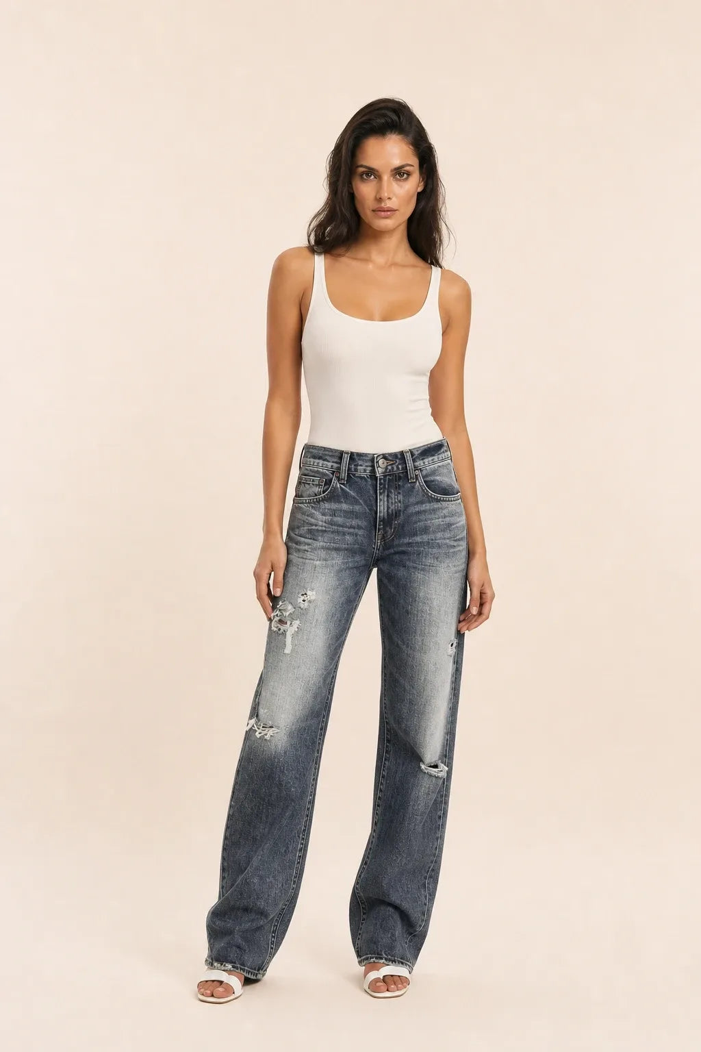 Gray distressed wide-leg jeans on a model in a contrapposto stance