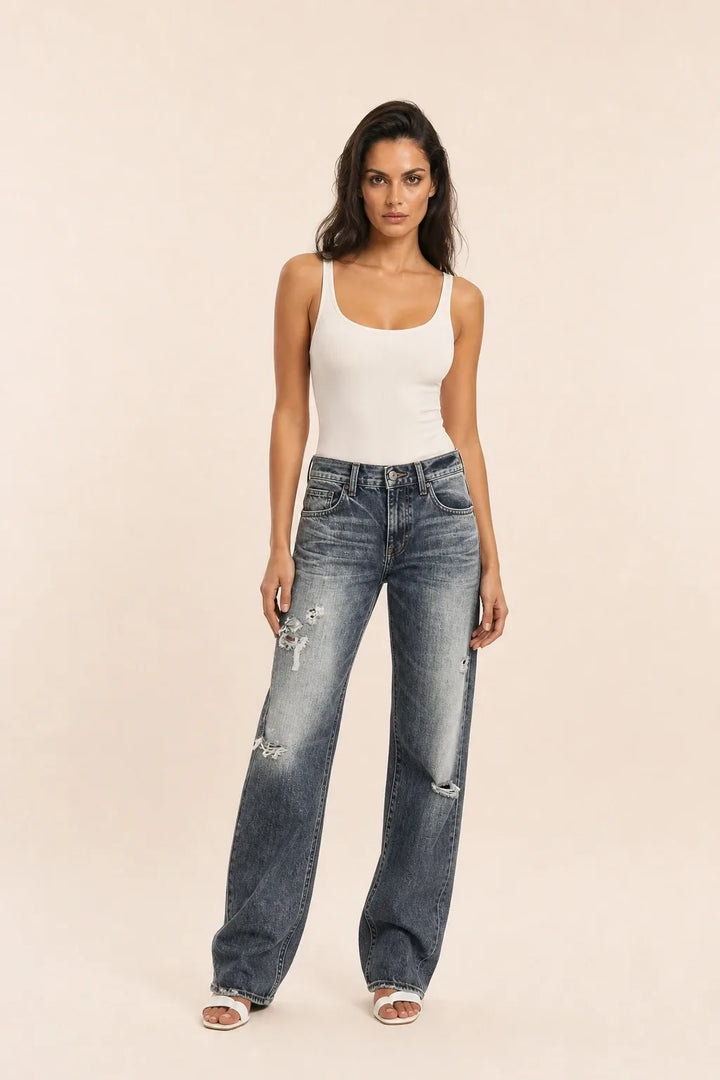 Gray distressed wide-leg jeans on a model in a contrapposto stance