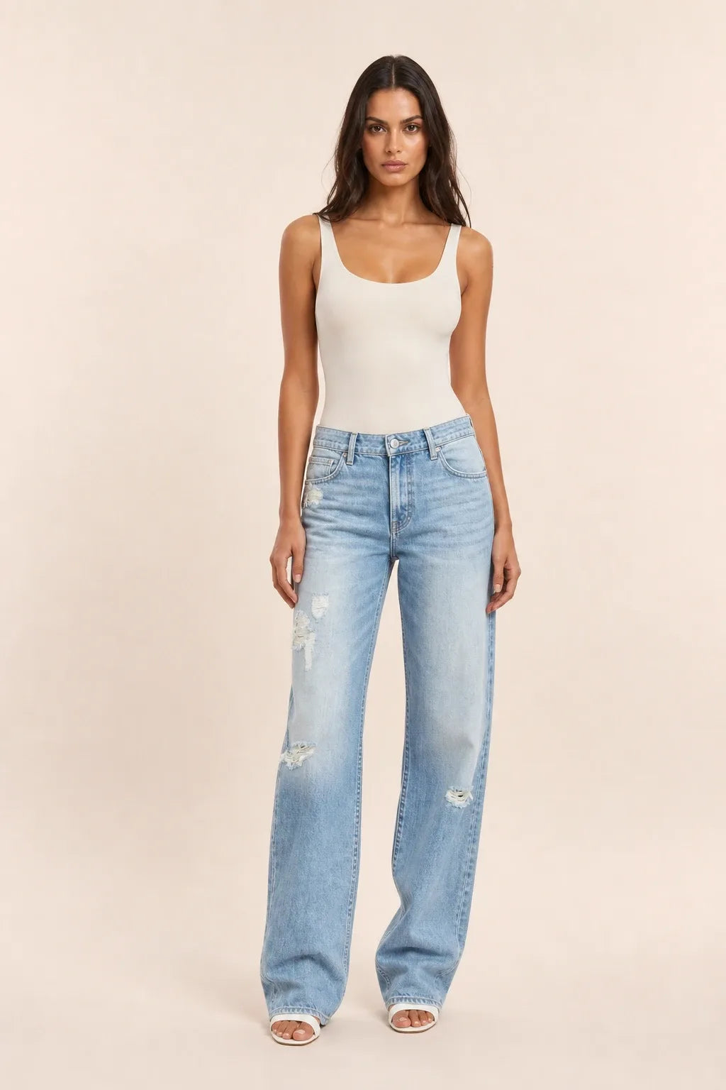 Light blue distressed wide-leg jeans on a model in a contrapposto stance