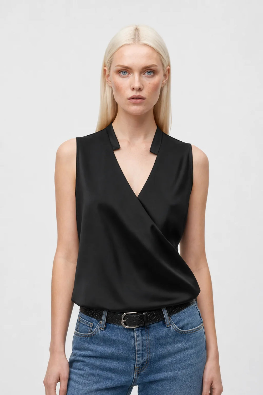 Black collared wrap blouse on model in contrapposto stance