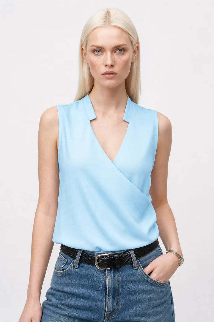 Light blue collared wrap blouse on model in contrapposto stance
