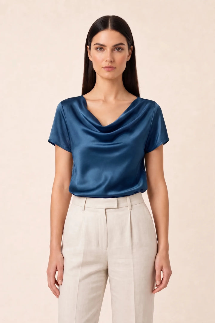 Blue satin cowl neck top on model in contrapposto stance