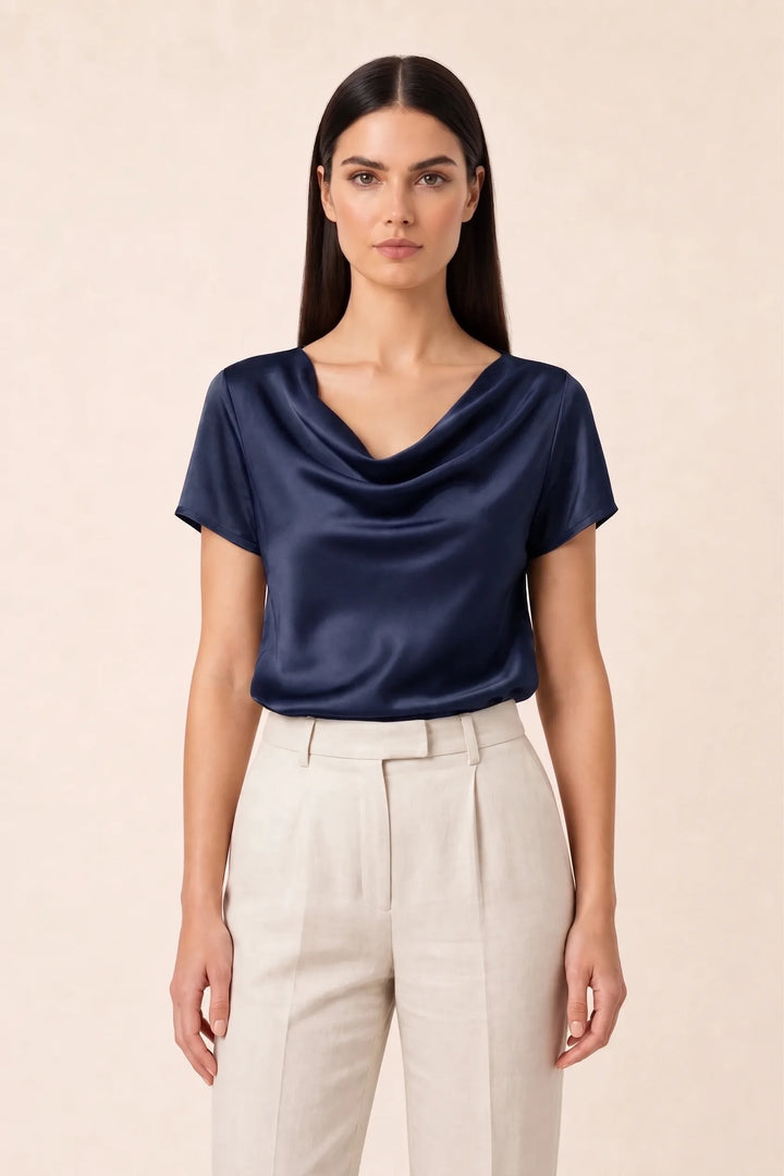 Navy blue satin cowl neck top on model in contrapposto stance