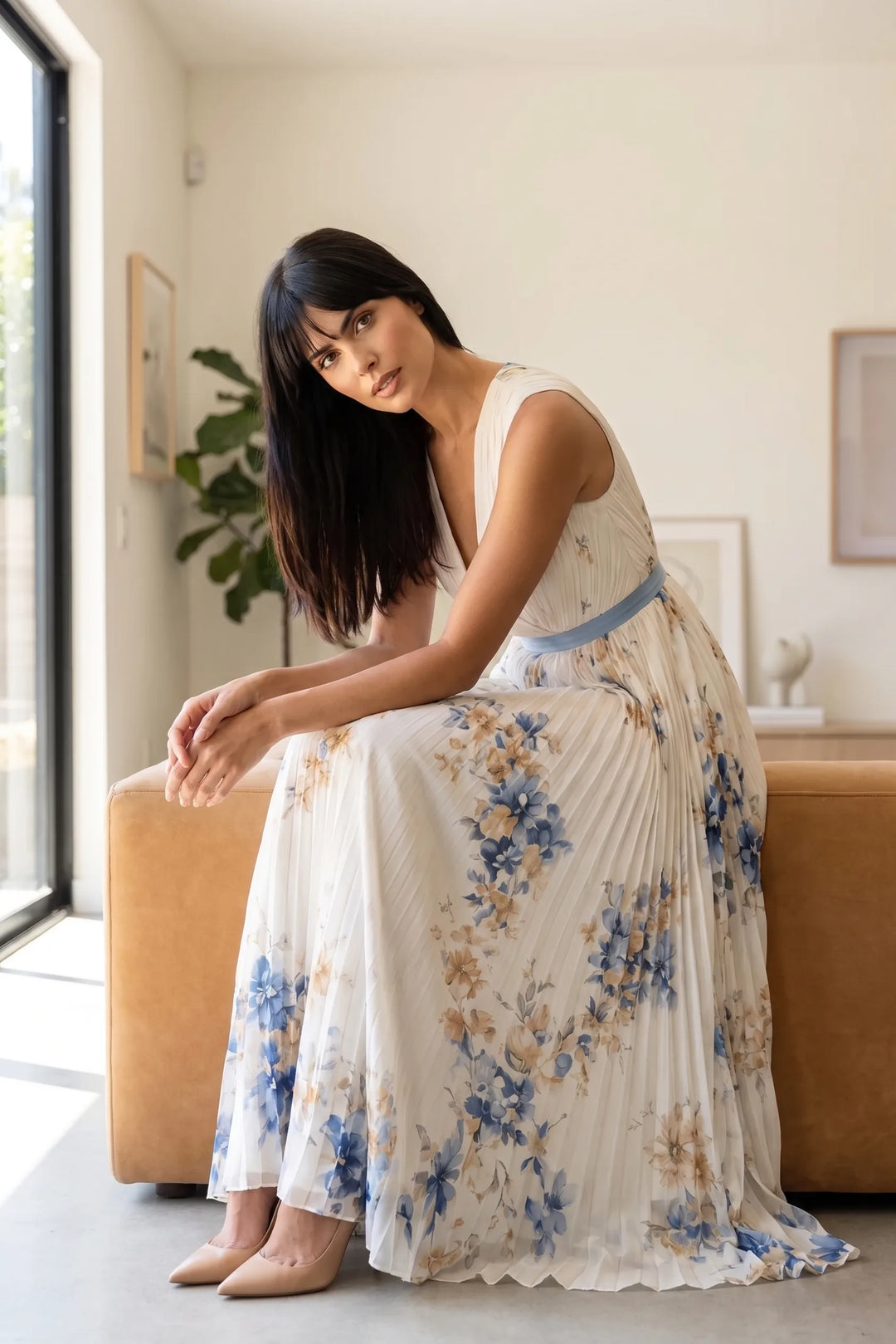 Model wearing beige pleated floral midi dress in outdoor lifestyle setting