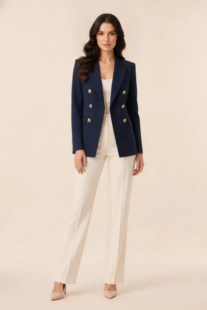 Black double-breasted blazer on model posed outside a storefront