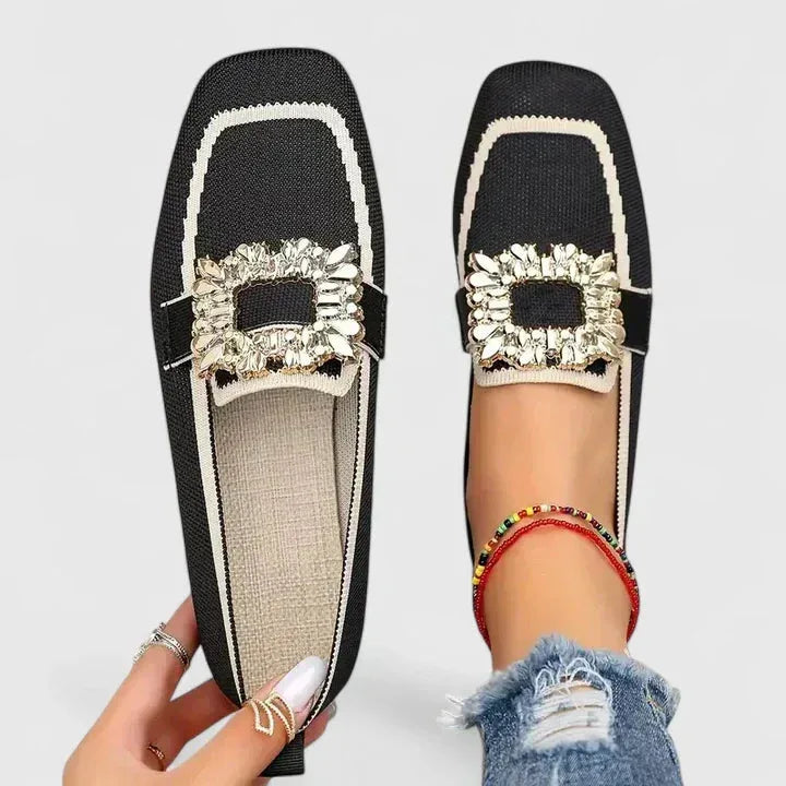 Black loafer with crystal buckle accent, side profile view