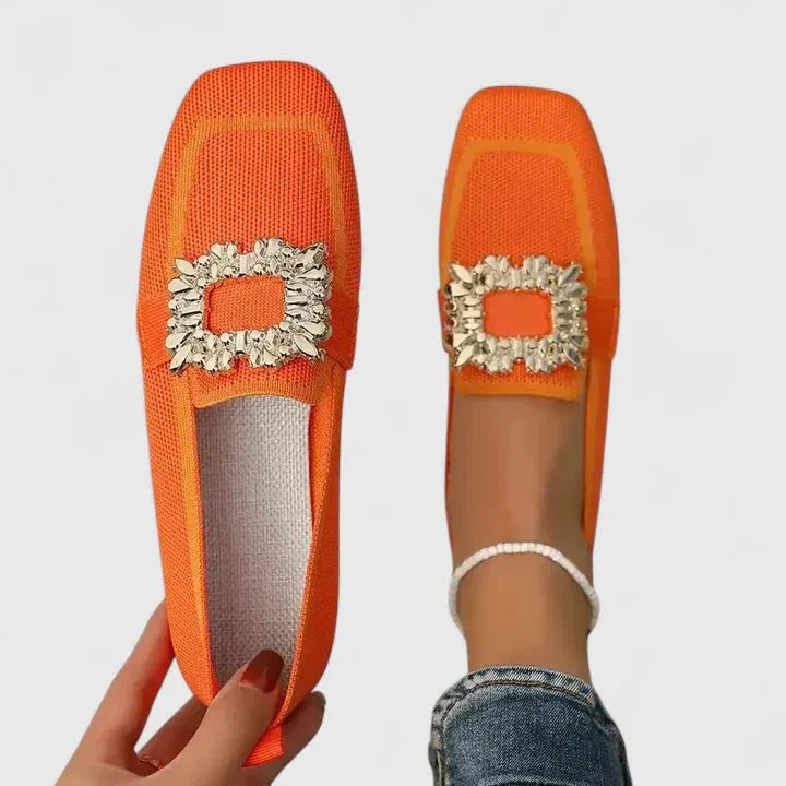 Close-up of crystal buckle detail on orange loafer