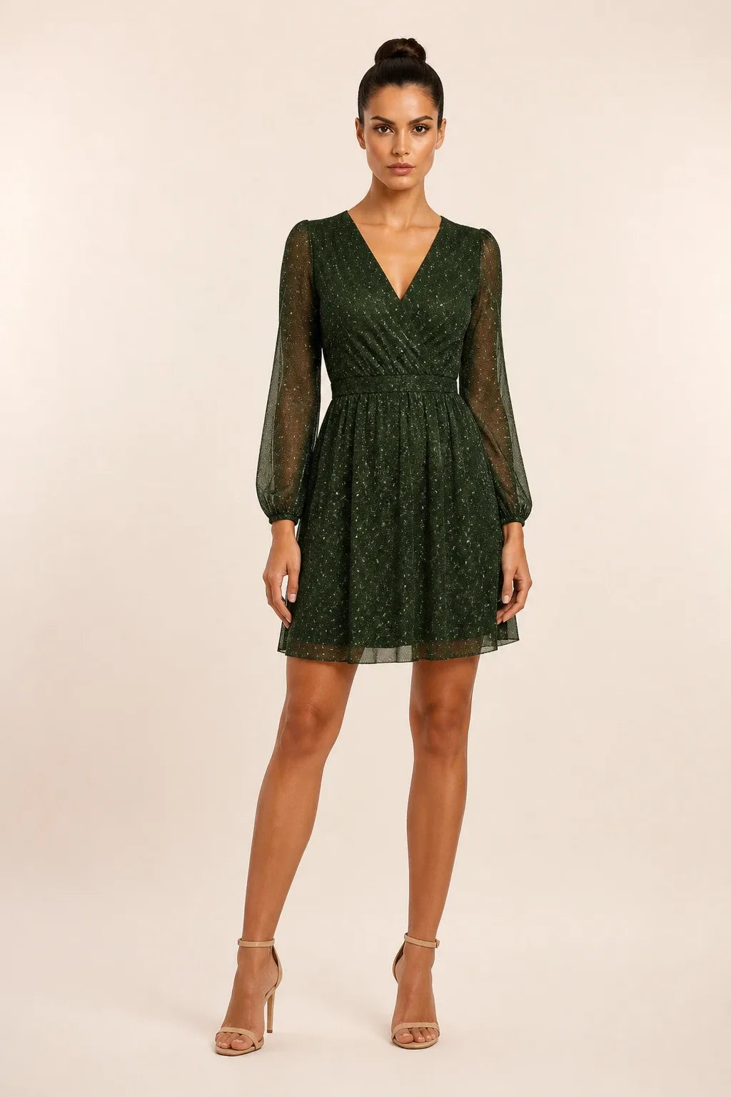 Green glitter mesh mini dress on a model in a contrapposto stance