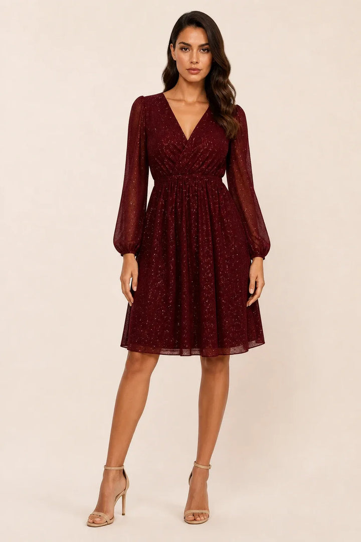 Red glitter mesh mini dress on a model in a contrapposto stance
