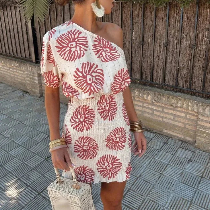 Woman facing forward in a white one-shoulder floral mini dress