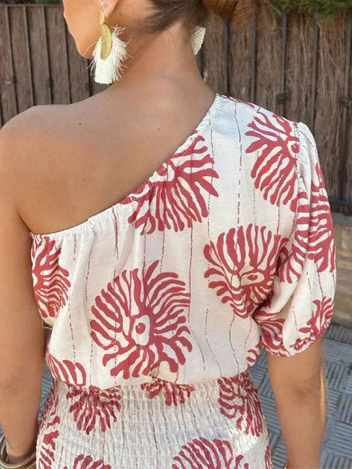 Woman in side profile wearing a white one-shoulder floral mini dress