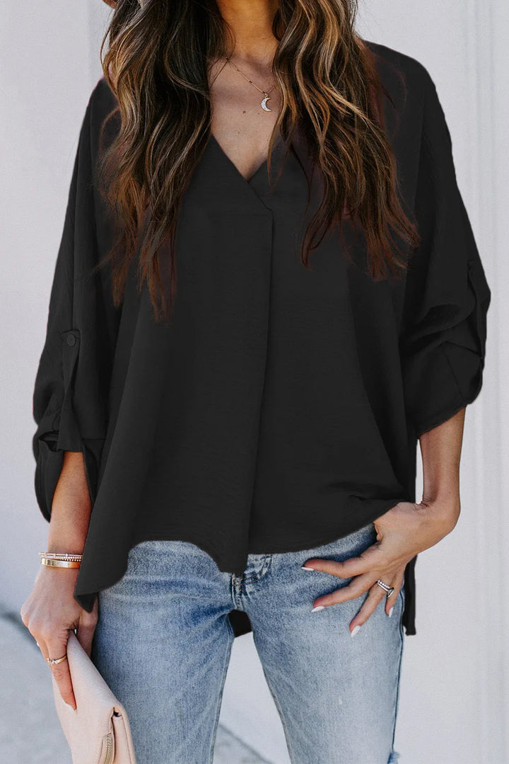 Black v-neck cuffed blouse, model shown from the side