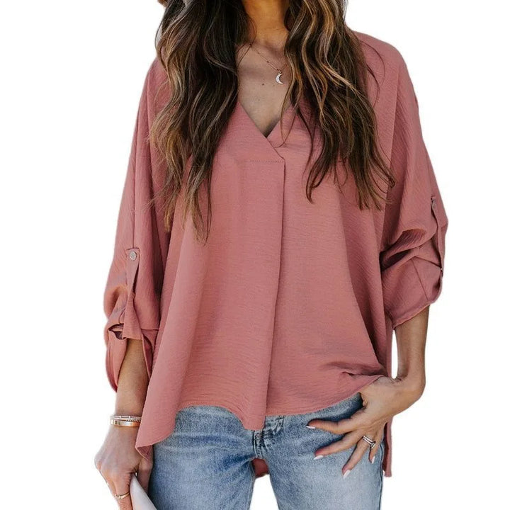 Pink v-neck cuffed blouse on standing model