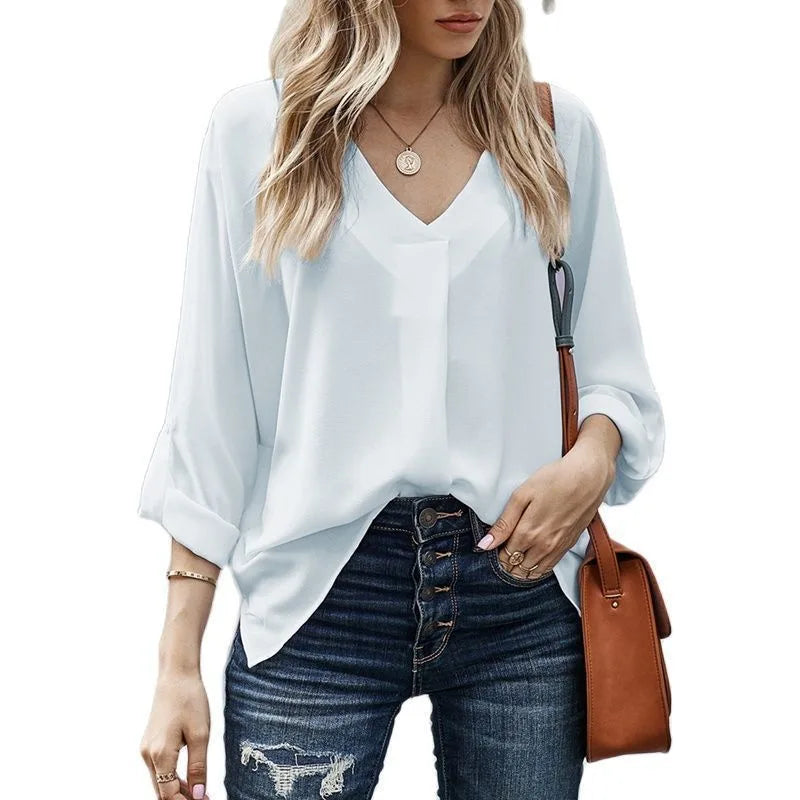 White v-neck cuffed blouse on standing model