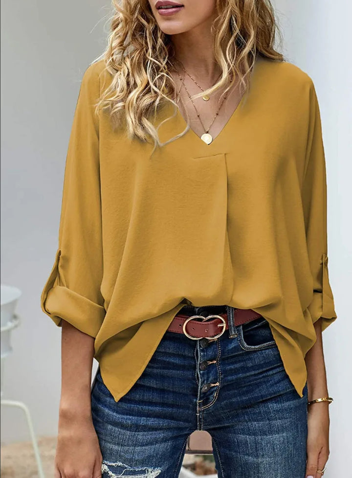Yellow v-neck cuffed blouse on standing model