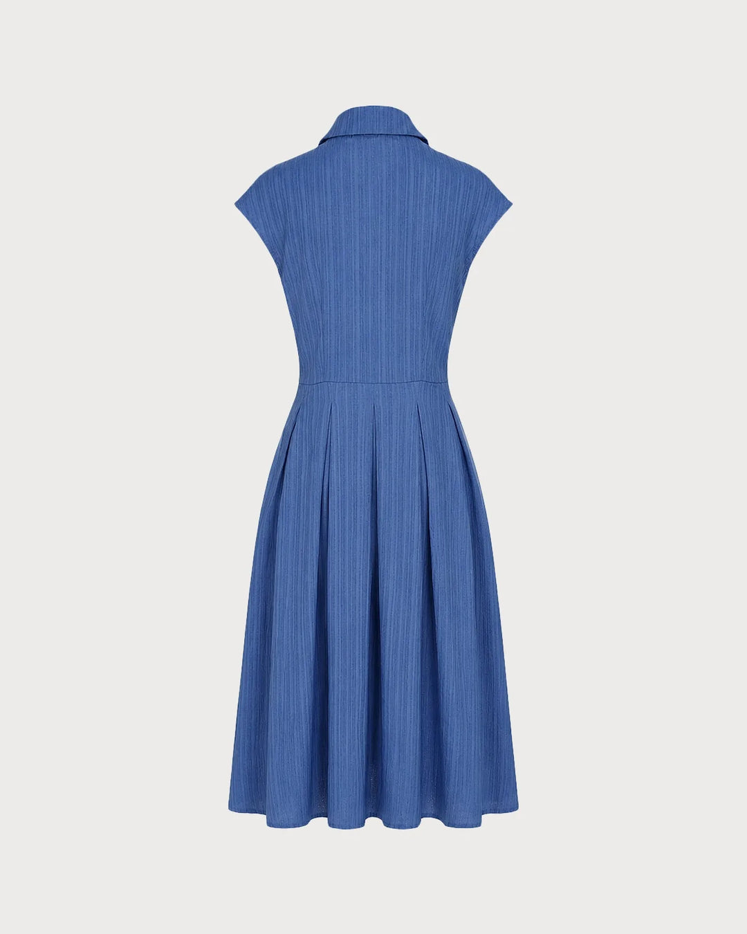 Model posing in a blue pleated midi dress with skirt drape visible