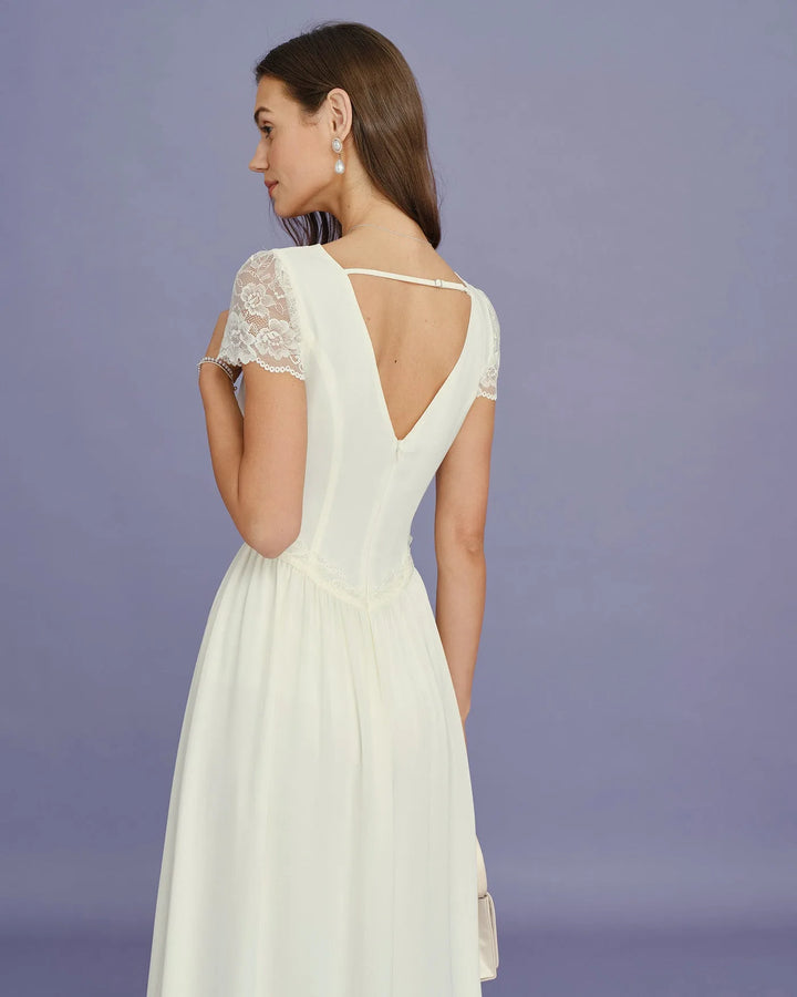 Model in side profile wearing apricot midi dress with lace sleeves