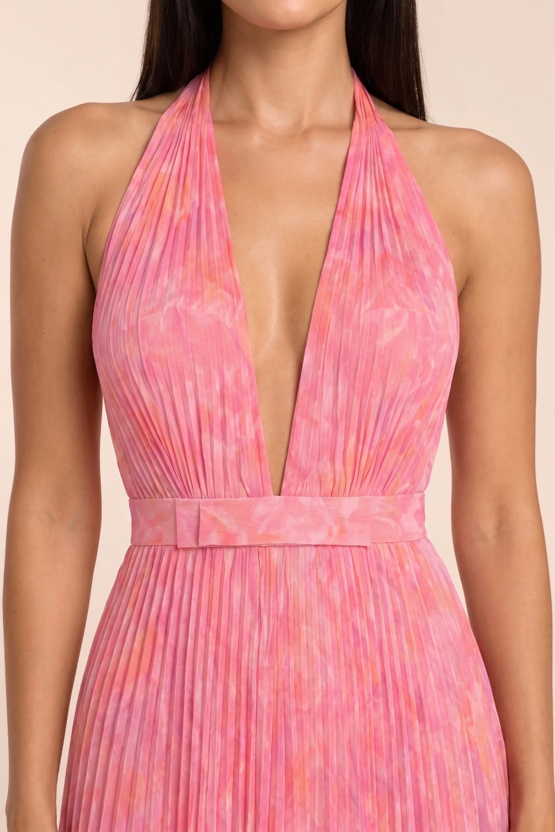 Close-up detail of pink pleated halter gown fabric and neckline