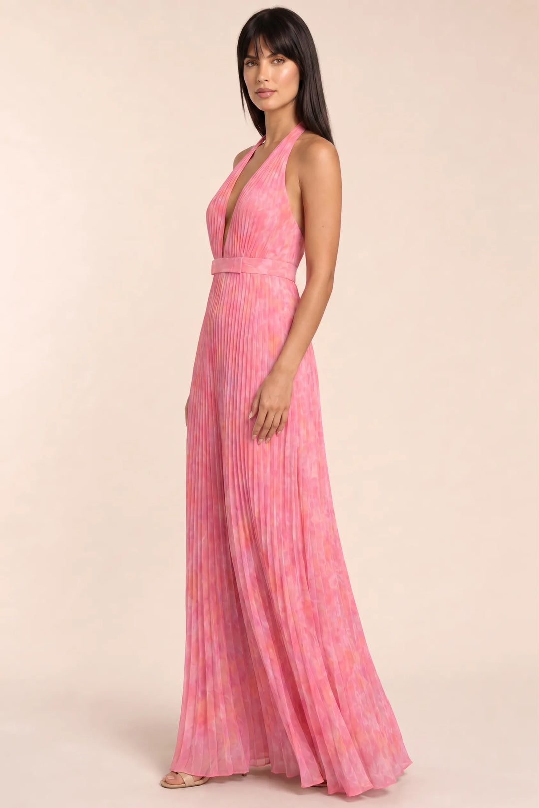 Pink pleated halter gown on model in three-quarter turn