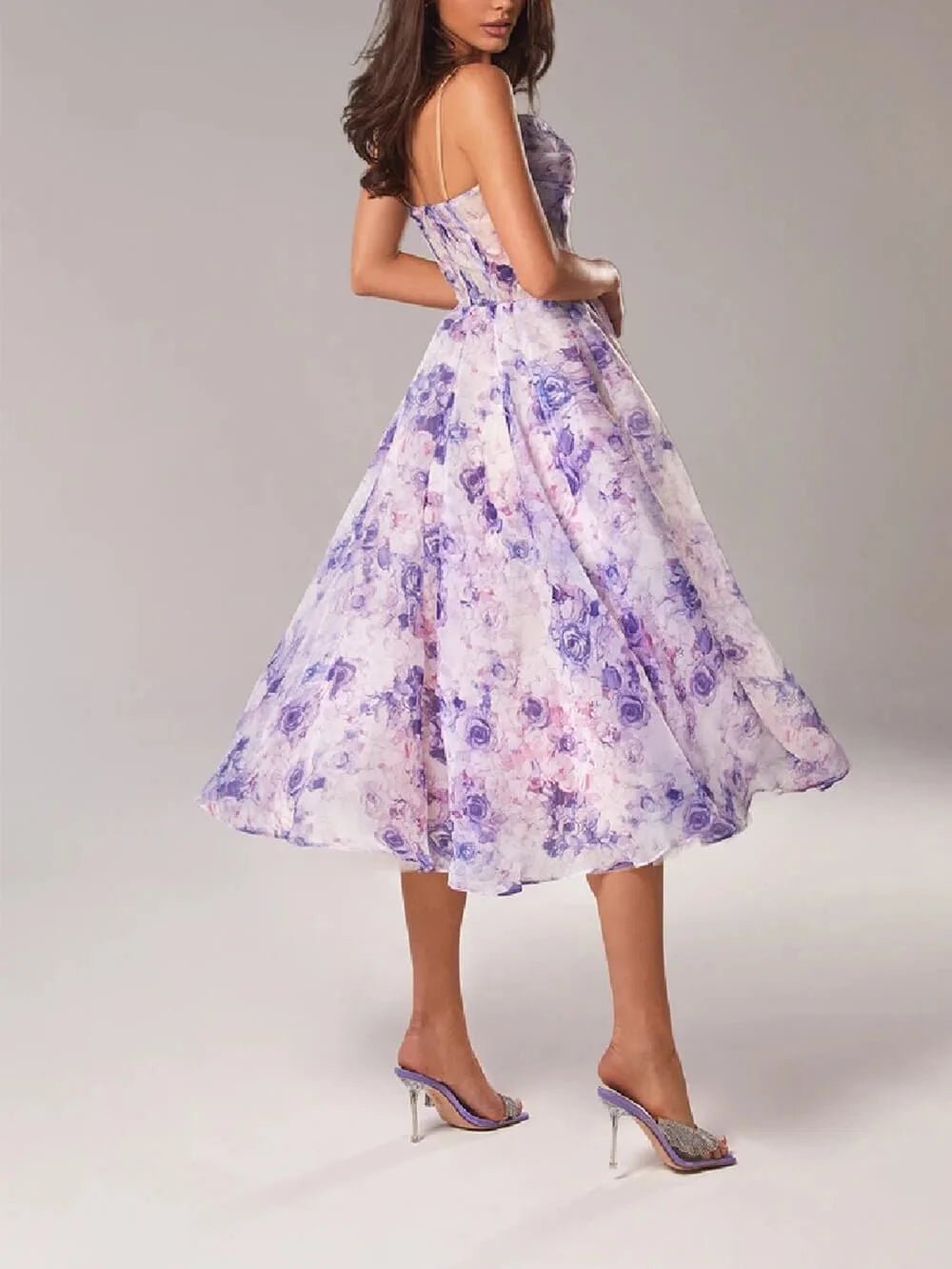 Woman wearing a pink floral corset midi dress, side profile view