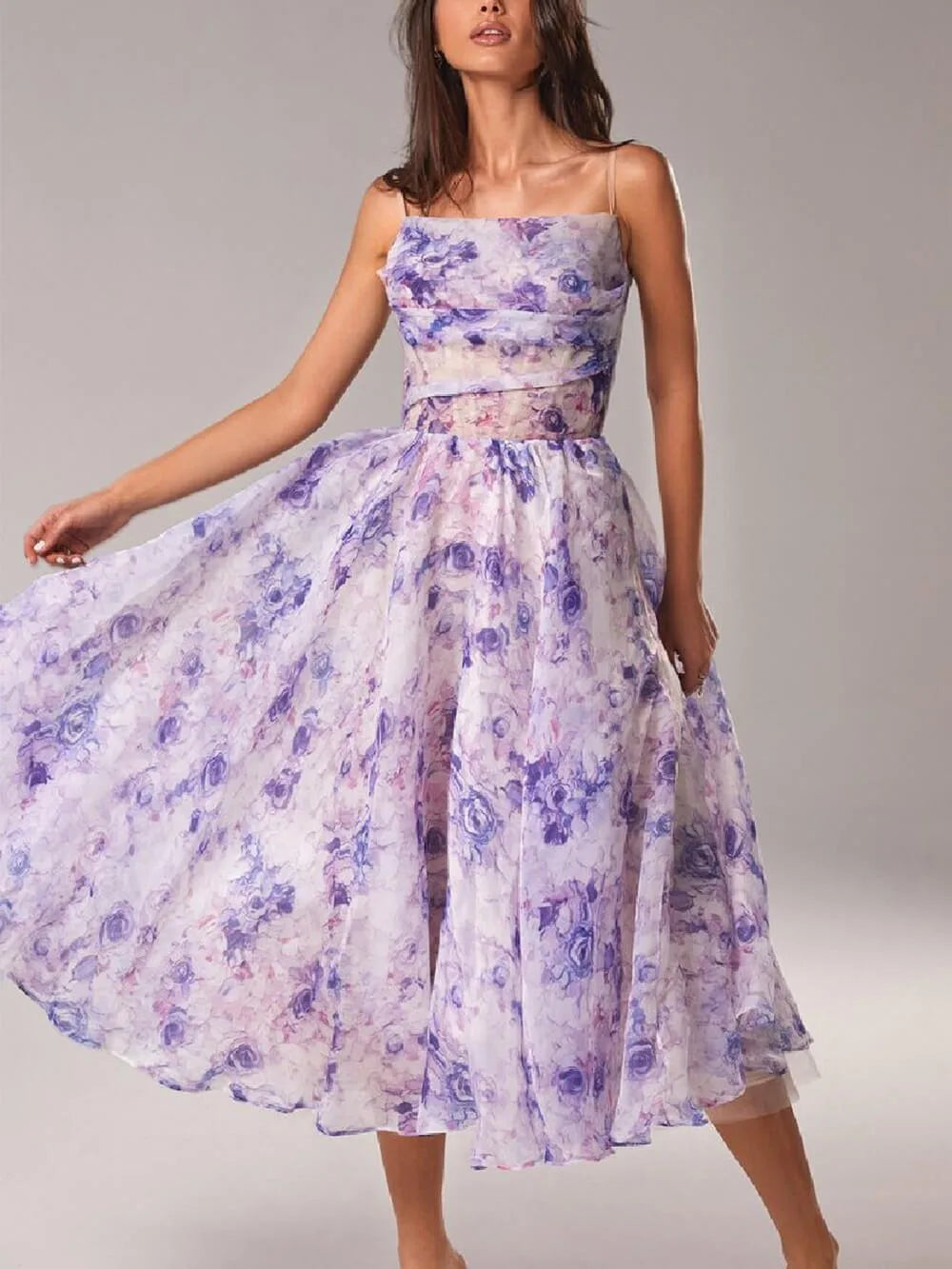 Woman wearing a purple floral corset midi dress, turned three-quarters