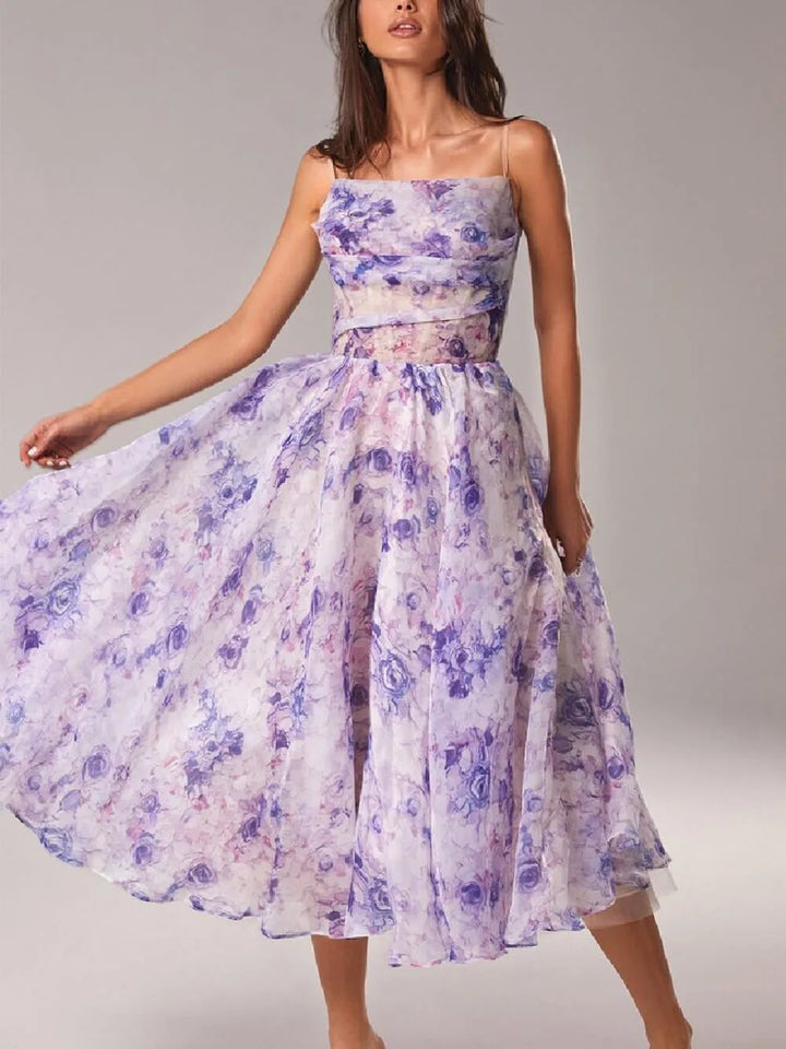 Woman wearing a purple floral corset midi dress, turned three-quarters