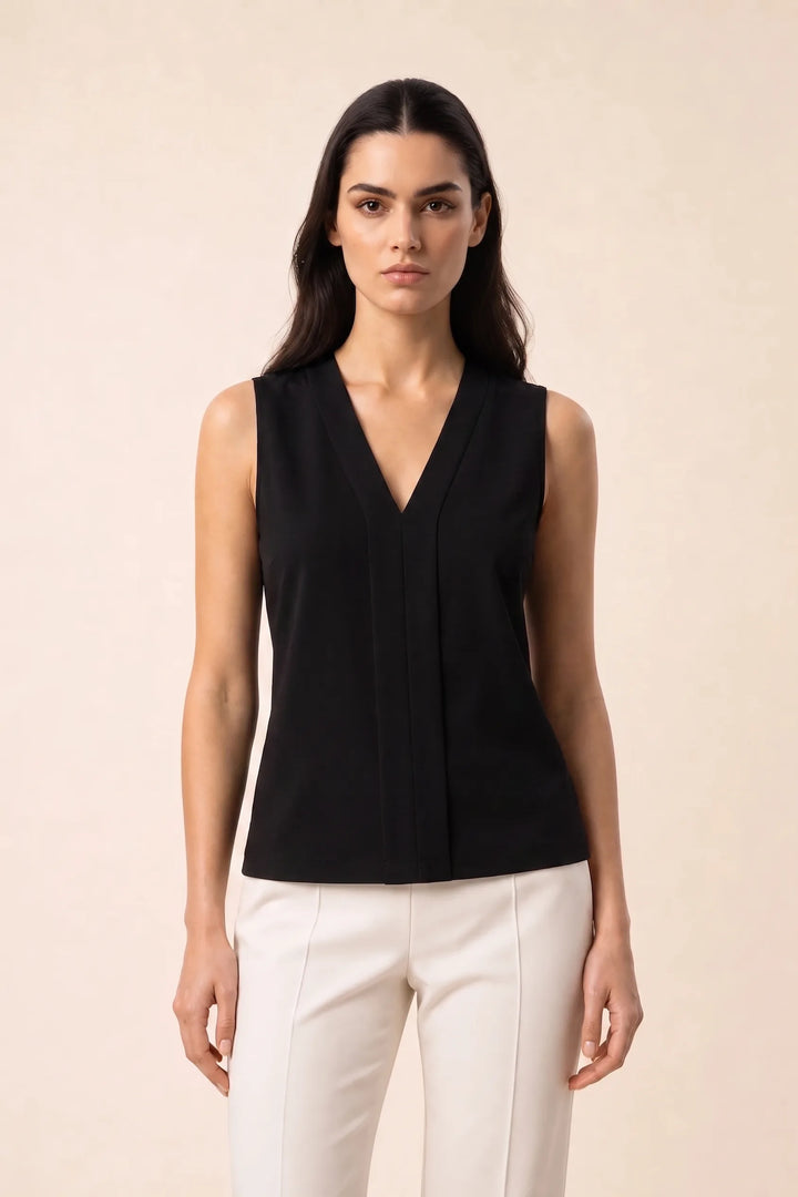 Black v-neck blouse with centre pleat detail, model in contrapposto stance