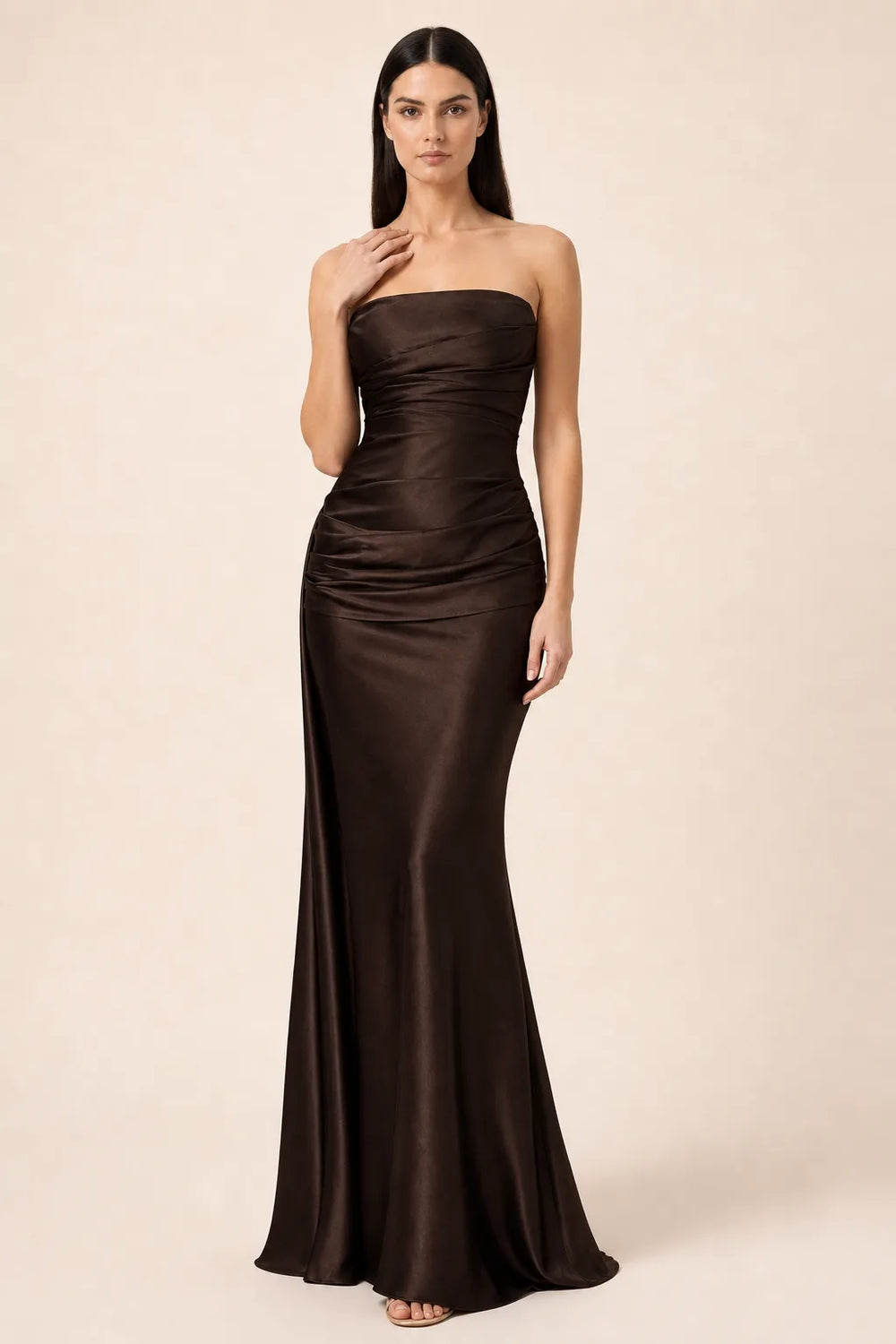 Brown ruched satin gown with gathered bodice and floor-length skirt, model in contrapposto stance