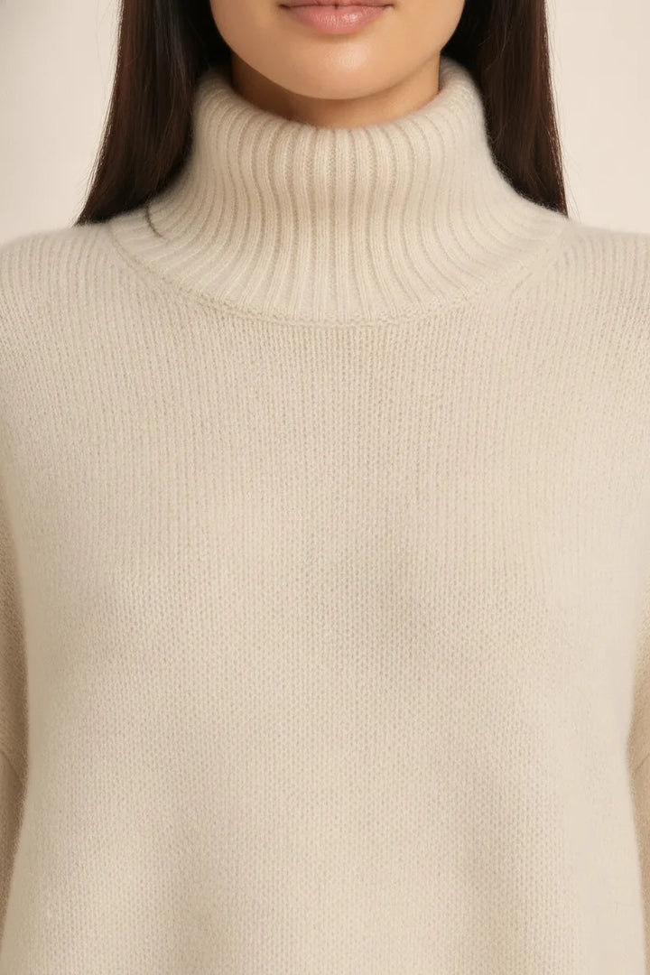 Close-up detail of a beige turtleneck knit pullover