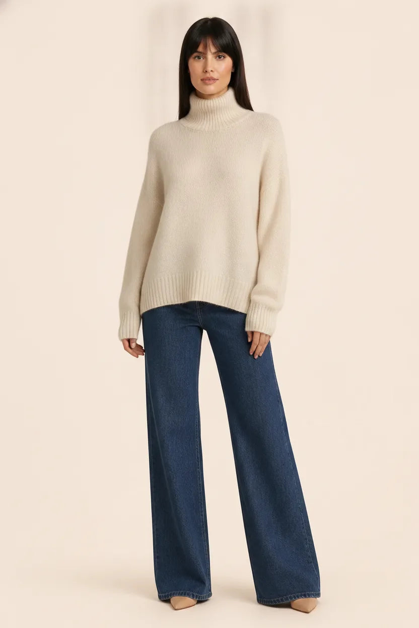 Beige turtleneck knit pullover on a model posed in front of a storefront