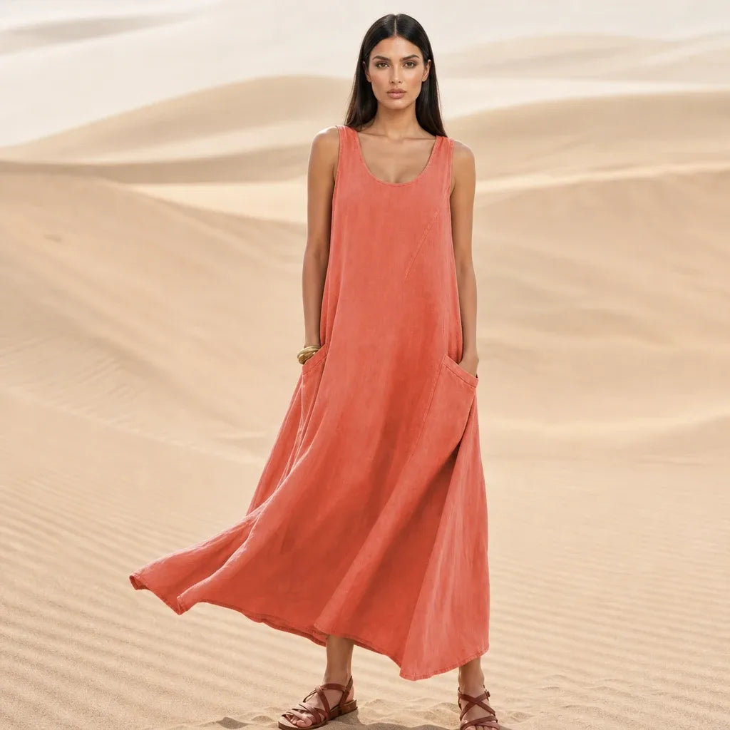 Orange maxi dress with side pockets, model standing in contrapposto pose