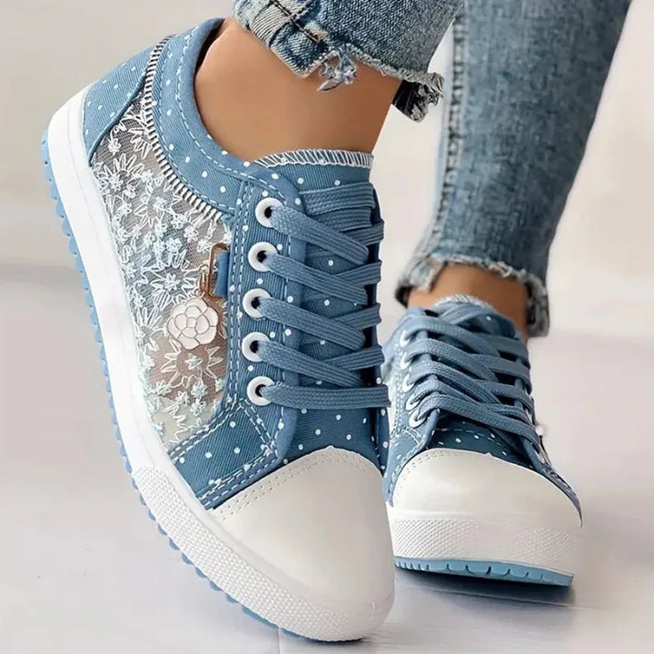 Close-up detail of embroidery and mesh texture on light blue platform sneaker