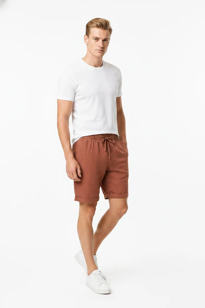 Orange linen drawstring shorts on a model in a three-quarter turn