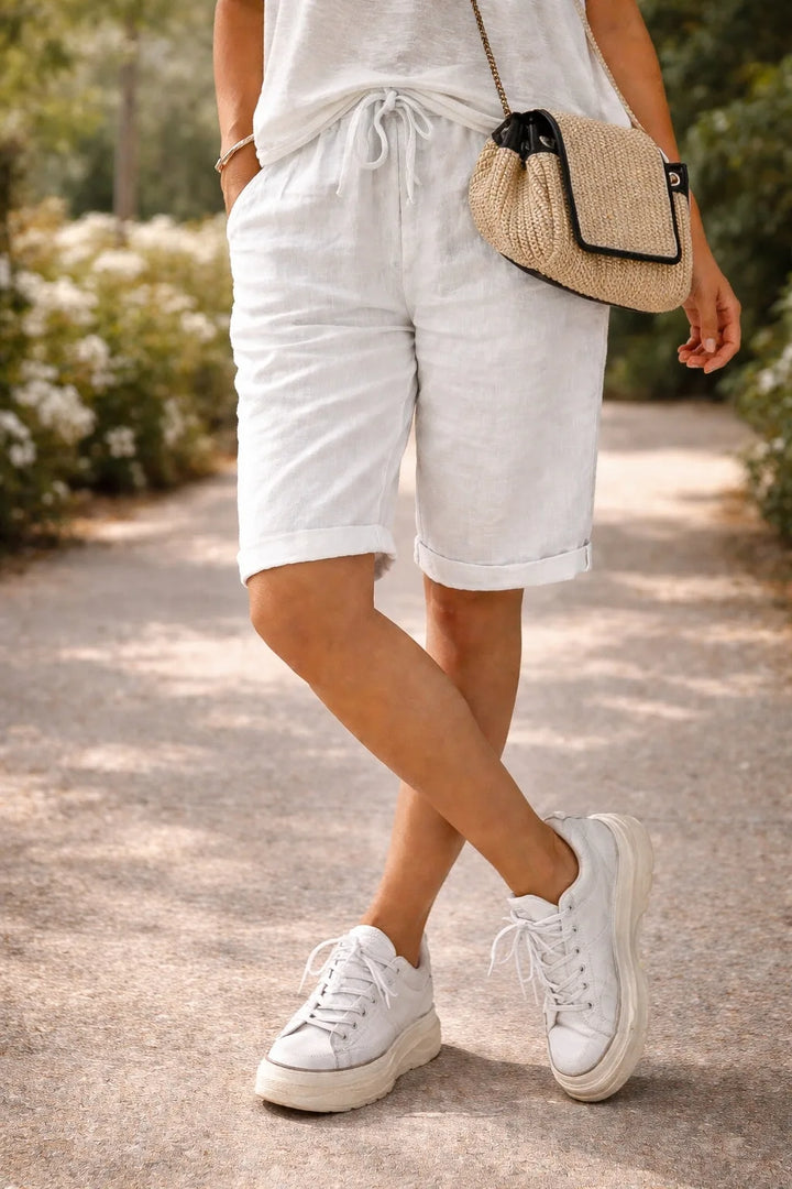 White drawstring Bermuda shorts on model, full-length view