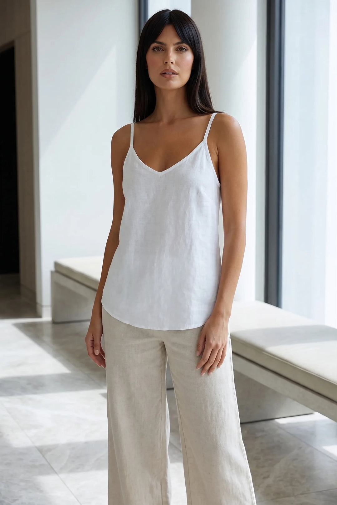 Model wearing white spaghetti strap cami in lifestyle setting