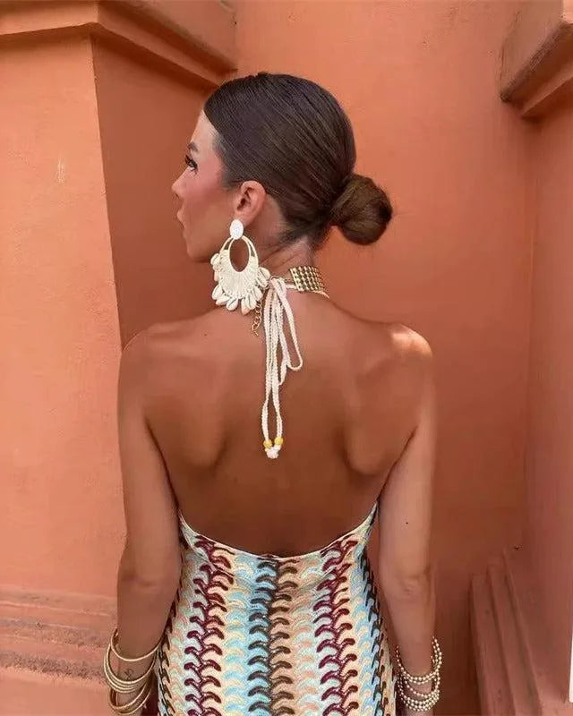 Woman in a beige multicolor crochet halter maxi dress shown from the side