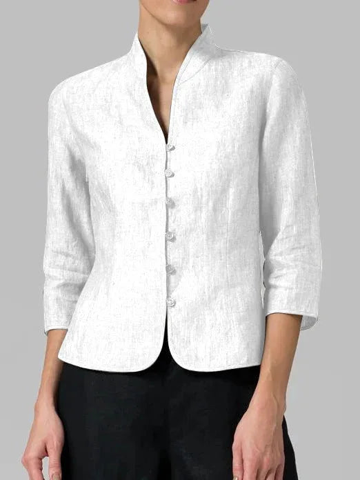 Model in a three-quarter turn wearing a white mandarin collar blouse