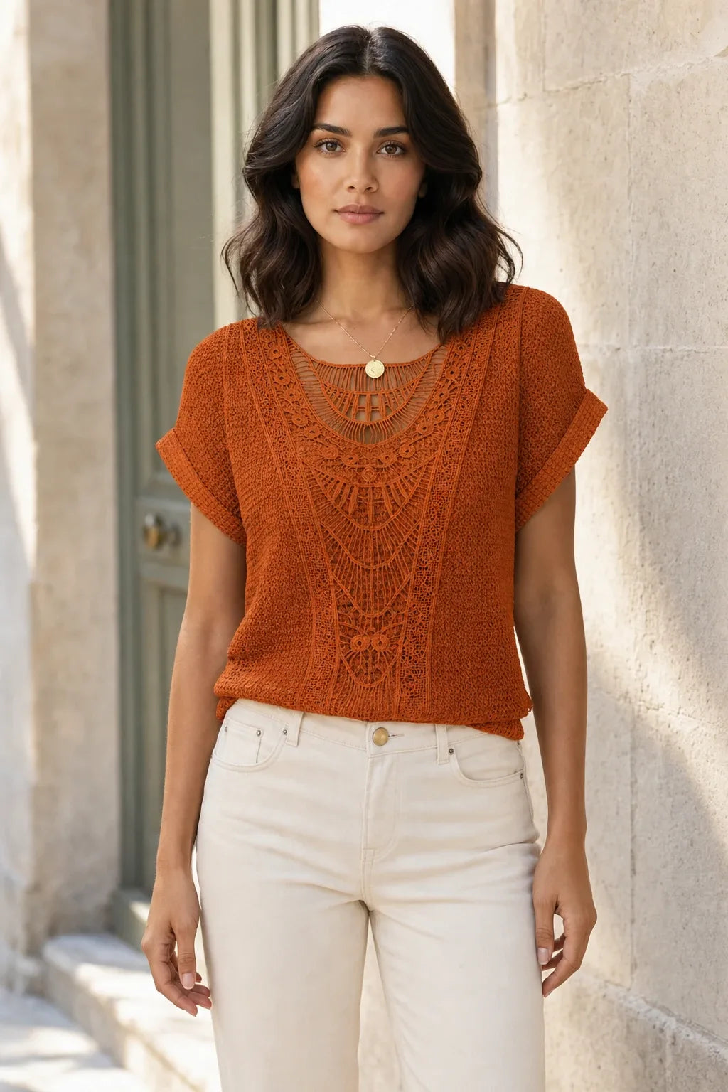Orange crochet panel top on model in contrapposto stance, front view