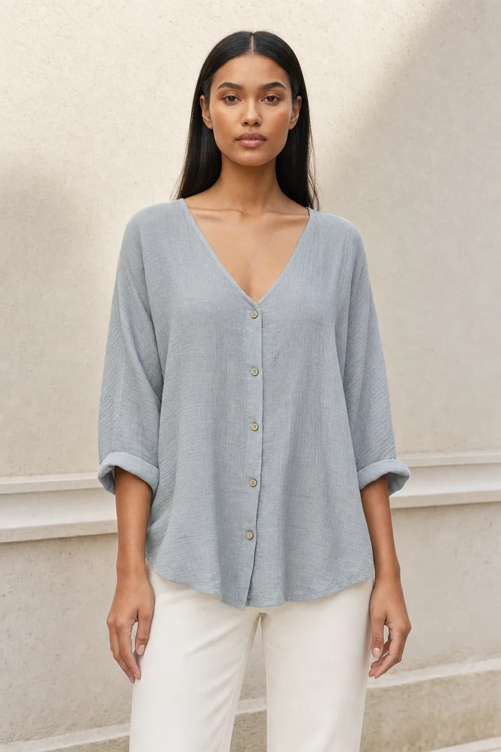 Model in a grey button-front relaxed blouse, standing in a contrapposto pose