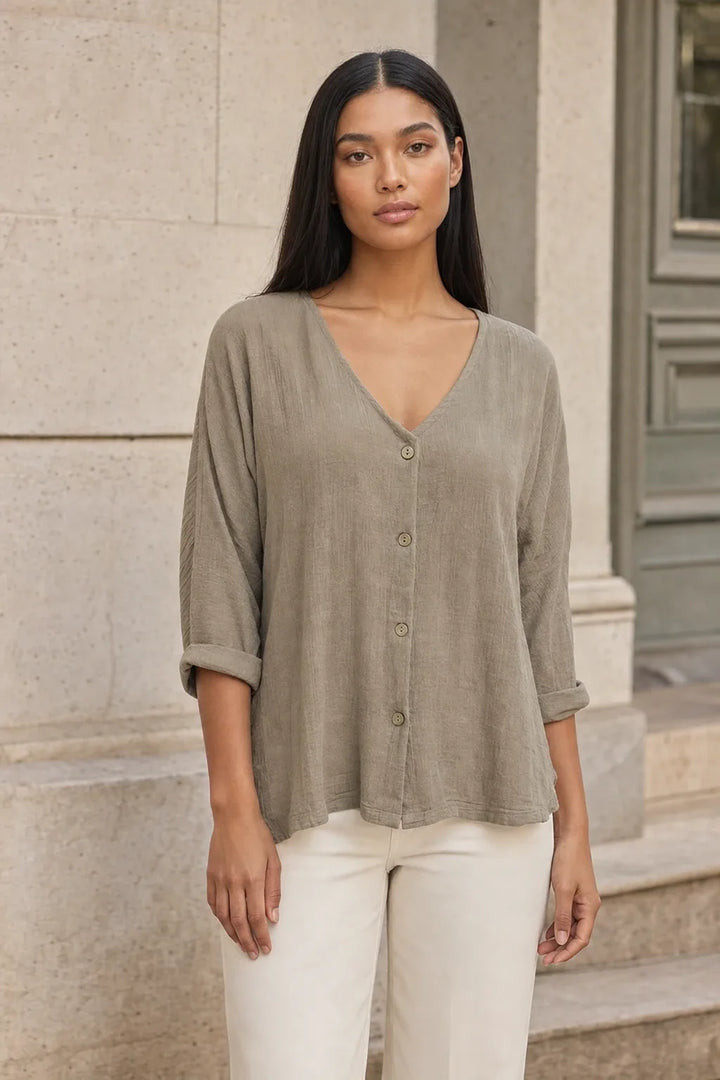 Model in a khaki button-front relaxed blouse, standing in a contrapposto pose