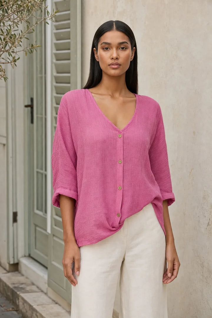 Model in a pink button-front relaxed blouse, standing in a contrapposto pose