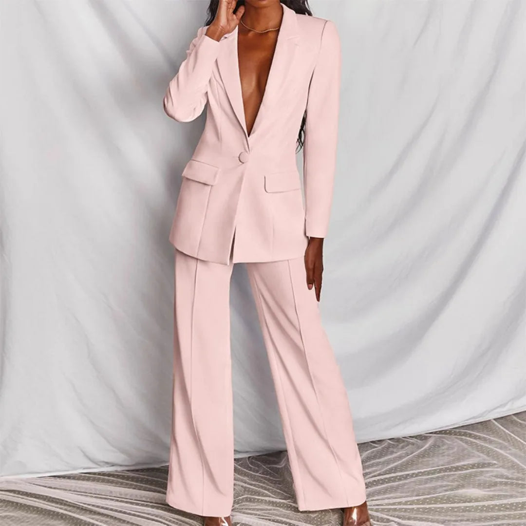 Woman wearing a light pink tailored blazer suit set, full-length view