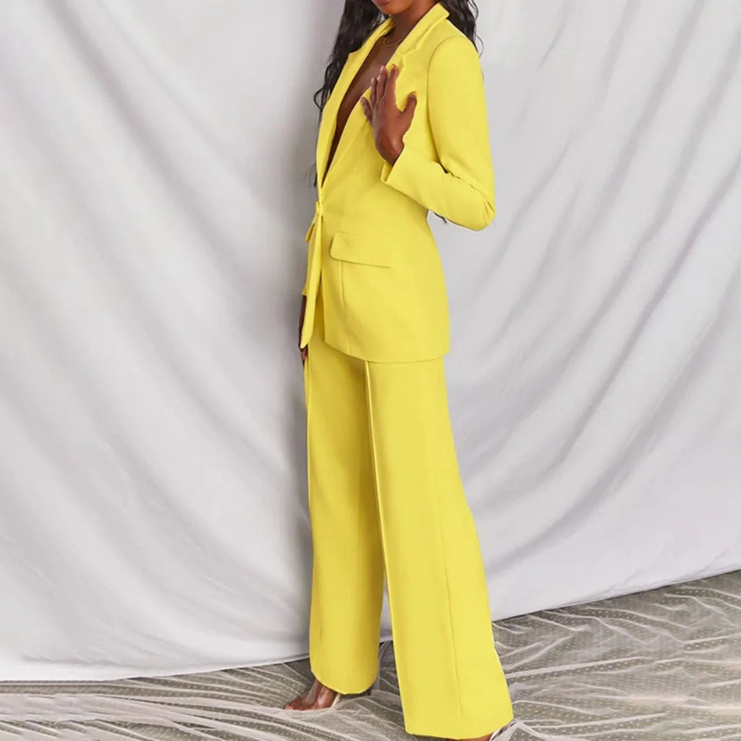 Woman in a yellow tailored blazer suit set, posed in a side profile view