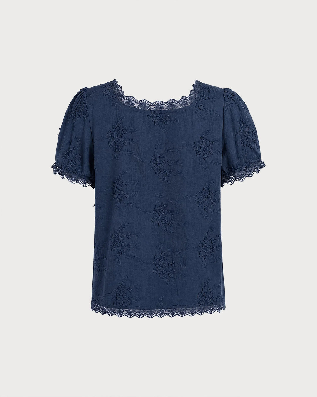 Model wearing a blue embroidered blouse with lace trim, viewed from the side