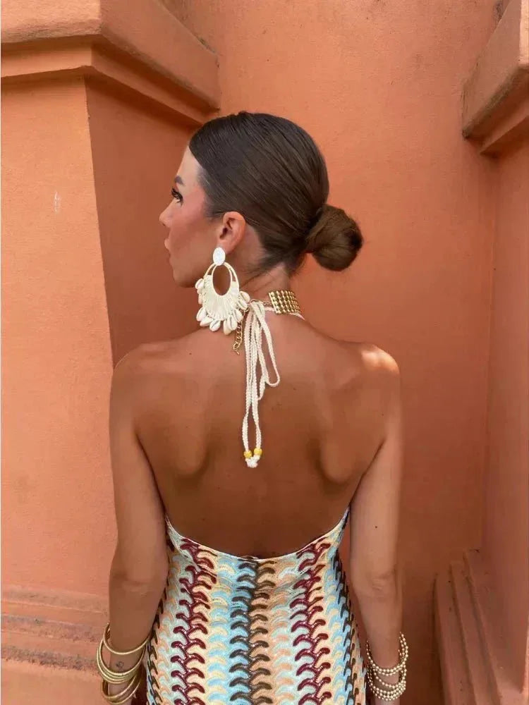 Model posing in a multicolor crochet halter maxi dress
