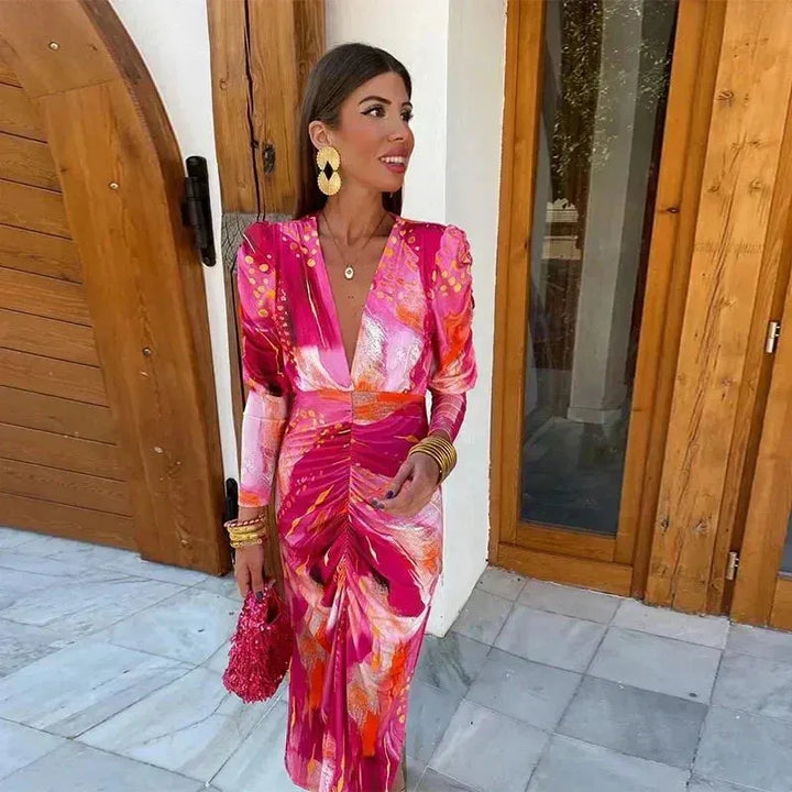 Woman wearing a pink ruched print midi dress, viewed from the side