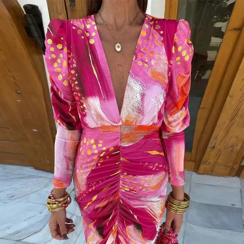 Woman wearing a pink ruched print midi dress, turned three-quarters to the right
