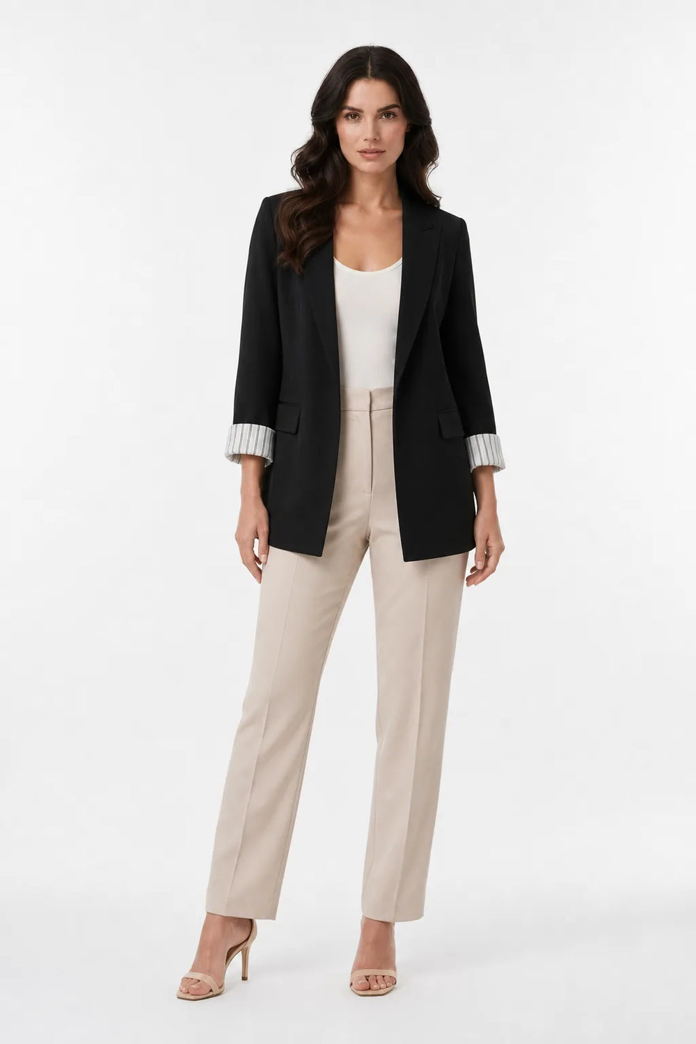 Black longline blazer with cuffed sleeves on a model in a contrapposto stance